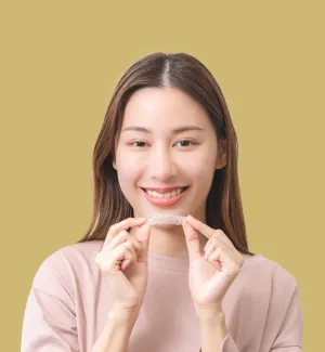 Teen holding Invisalign aligner